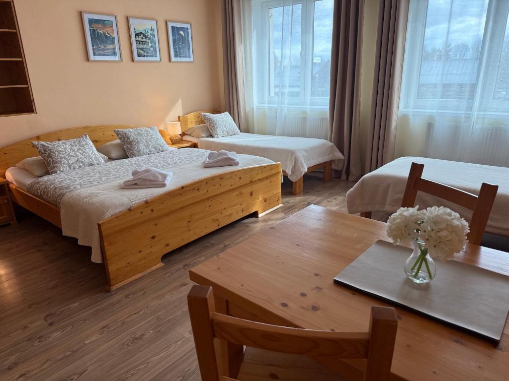 a hotel room with two beds and a table at Quota 850 in Tatranská Lomnica