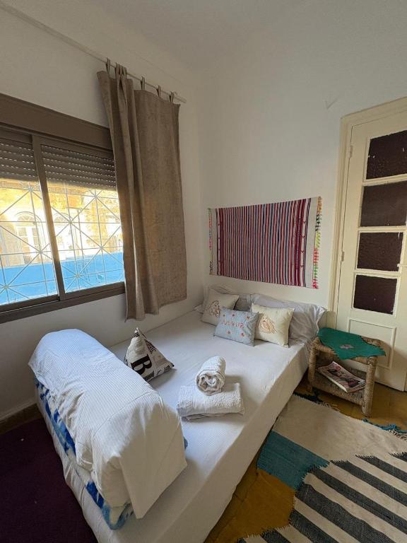 a room with two beds and a window at Studio coeur tanger in Tangier