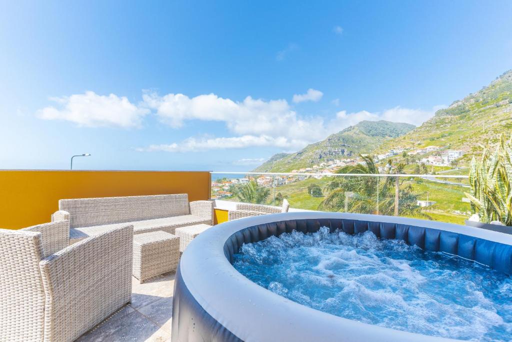 a hot tub on a patio with a view of the ocean at Recanto do Sol by Atlantic Holiday in Caniçal