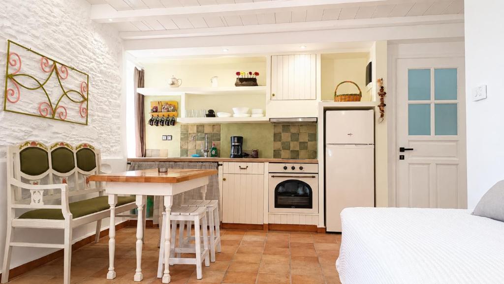 a kitchen with white cabinets and a table at Est 1852 Andros - Tower 2 in Lámira
