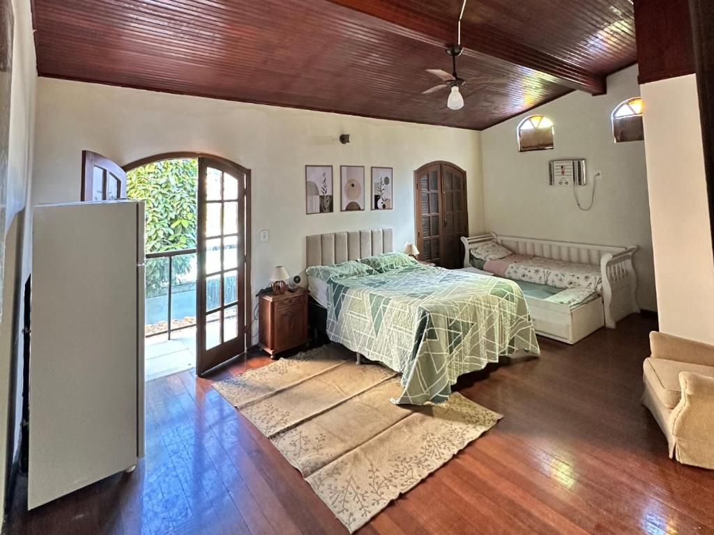 a bedroom with a bed and a couch in a room at Hospedaria Clã do Cla in Arraial do Cabo