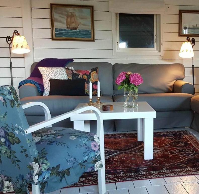 sala de estar con sofá y mesa con flores en Kronobergs Gård i Gladsax en Simrishamn