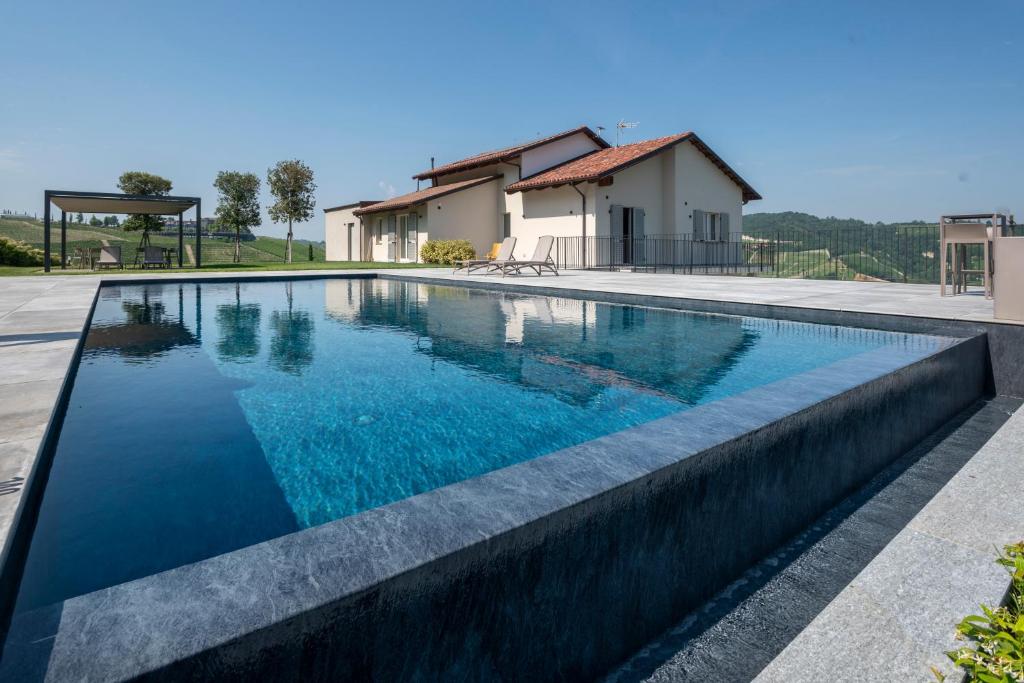 a swimming pool in front of a house at Radici in Serralunga d'Alba