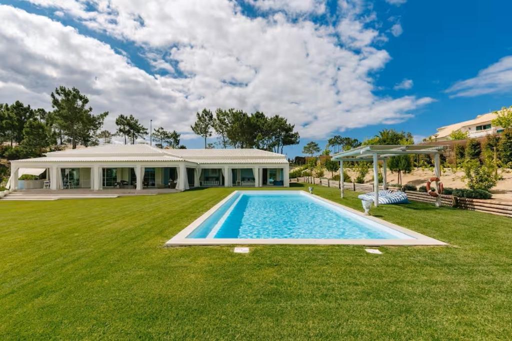 a large yard with a swimming pool and a house at Villa Lottus in Carvalhal