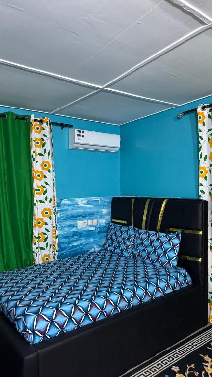 a bed in a room with a blue wall at King Appartement in Lomé