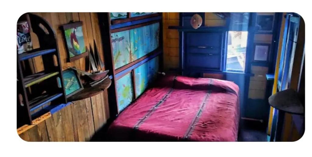 a small bedroom with a red bed in a room at Kismet Inn Semi Private in Hopkins