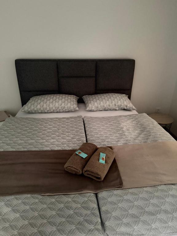 a bed with two towels on top of it at Apartma Viković II in Njiverce