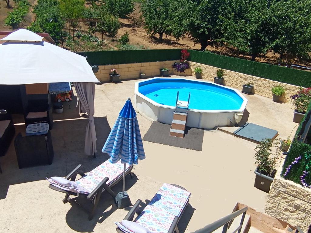 an overhead view of a swimming pool with chairs and an umbrella at Casa Carla in Sotoserrano