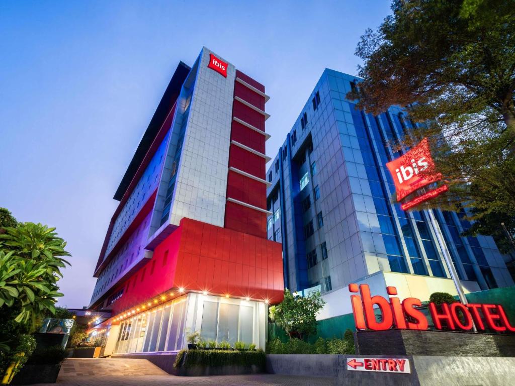 a building with a bus hotel sign in front of it at Ibis Jakarta Senen in Jakarta