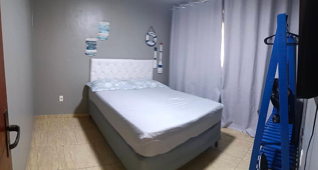 a small white bed in a room with a window at Verde Mar Abricó 4 in Rio das Ostras