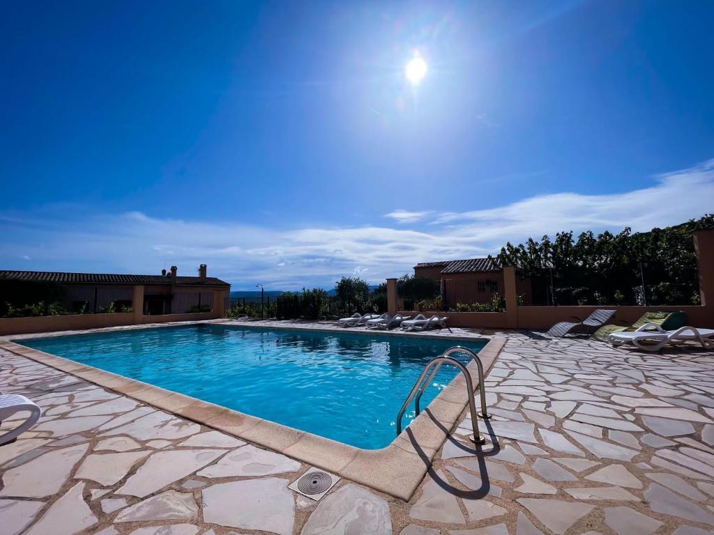 a swimming pool with a chair next to a building at Les Oliviers in Grimaud