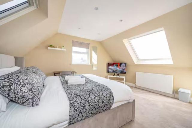 a bedroom with a large bed with two pillows at RA7C Stylish Loft Stay in Batley