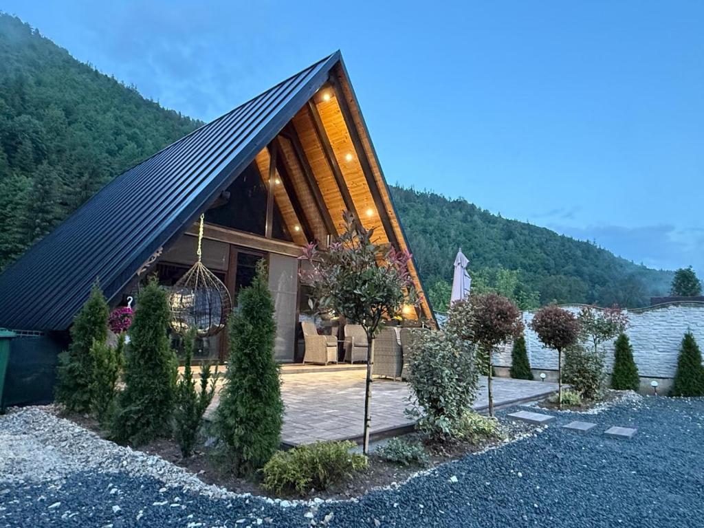 ein Haus mit Satteldach auf einem Hügel in der Unterkunft A-frame Cernat in Albac