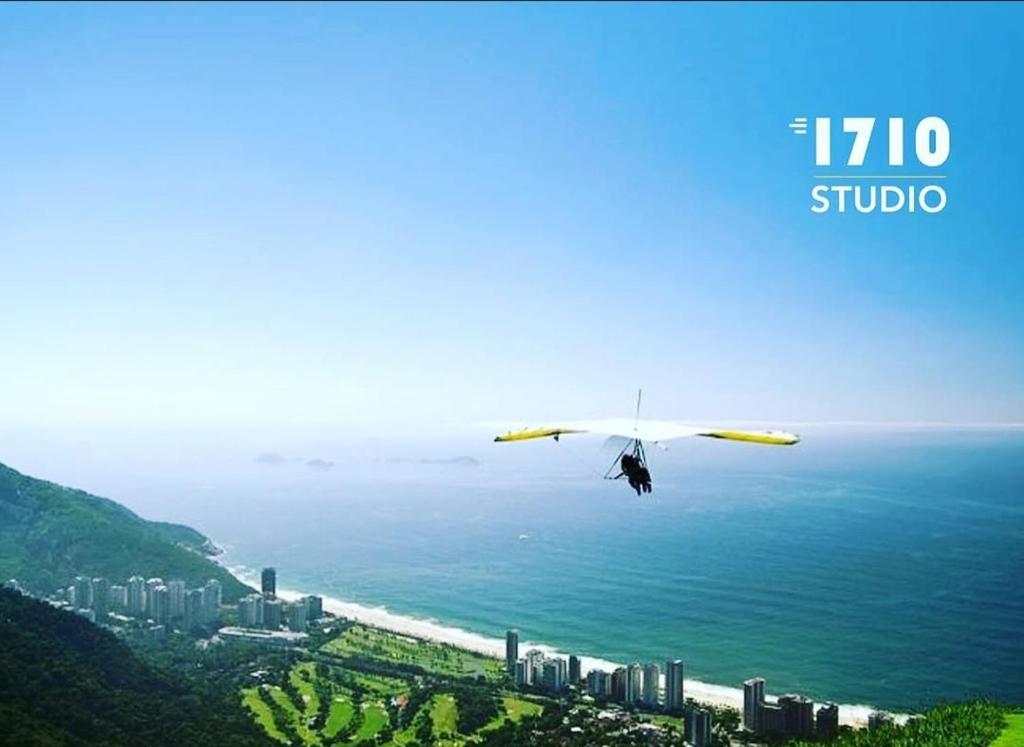 a plane flying over the ocean with a city at Hotel Nacional in Rio de Janeiro