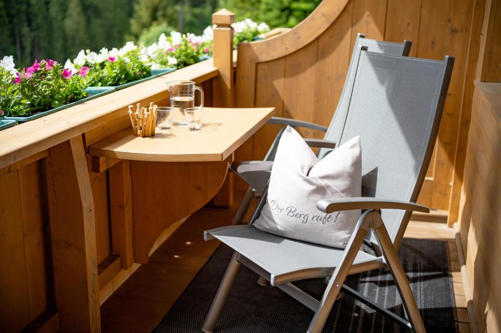 a table and a chair with a bag on a balcony at Ferienwohnungen Luxner in Gerlos