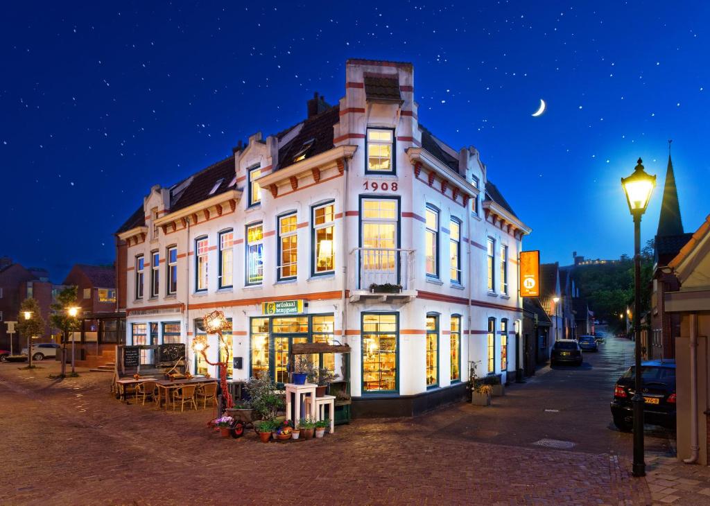 a large white building on a street at night at Be my Guest House in Wijk aan Zee