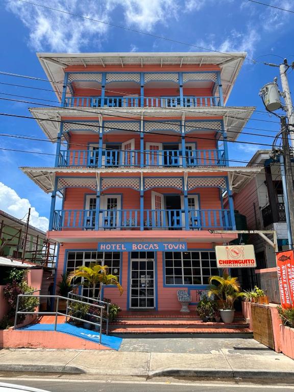a red building with blue balconies on a street at Hotel Bocas Town in Bocas Town