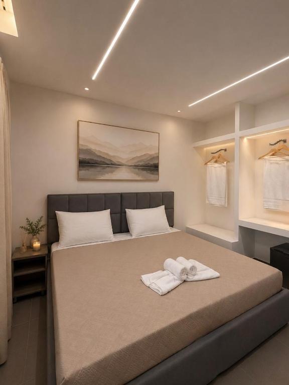 a bedroom with a large bed with towels on it at Aura Rooms in Delvinë