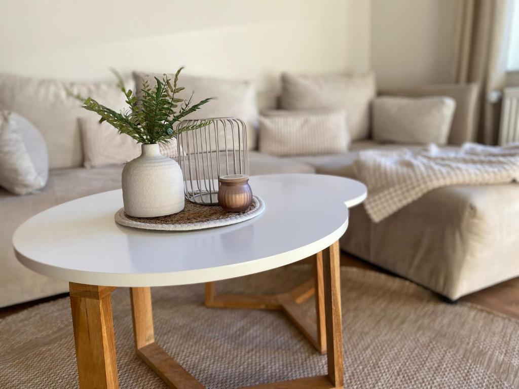 a white table with a vase on it in a living room at Casa Piedra in Kleinsteinhausen