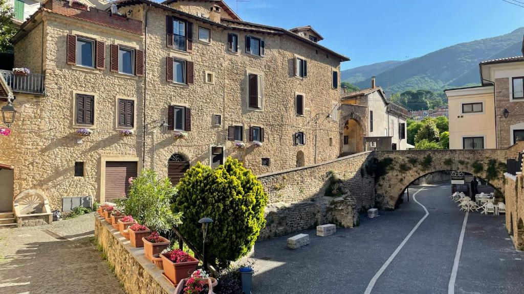 an old stone building with an arch in a street at Residenza La Gemma in Subiaco