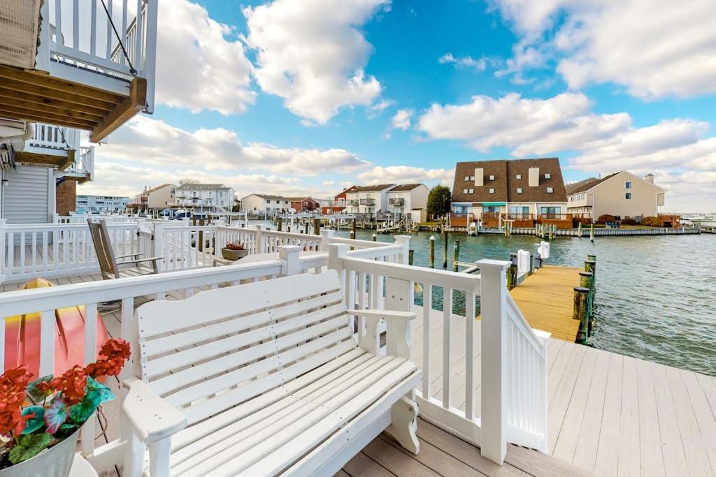 a white bench sitting on a dock next to the water at Gullway Getaway in Ocean City