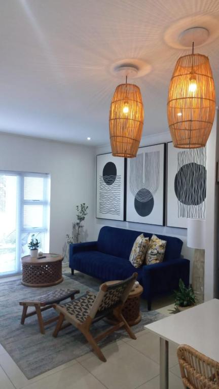 a living room with a blue couch and two lamps at Anyomi Zen in Gqeberha