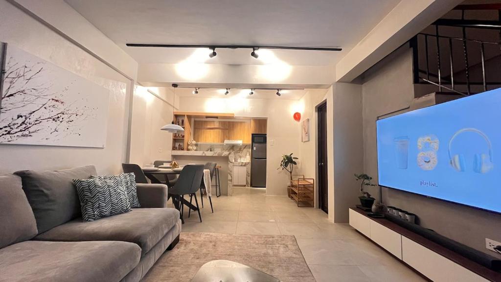 a living room with a couch and a flat screen tv at CHL Pod in General Trias