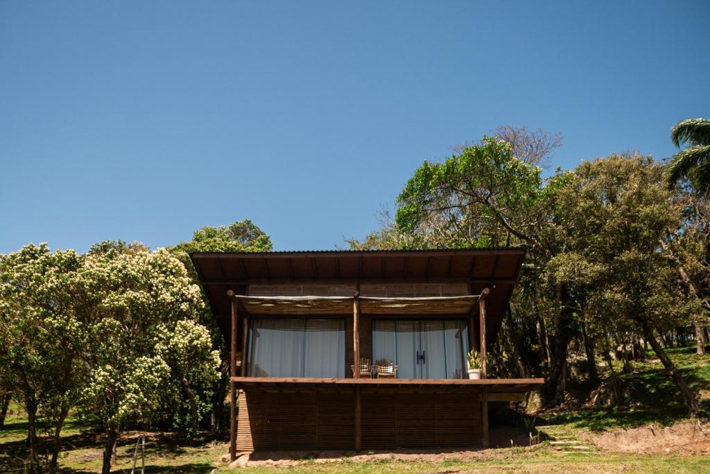 a small house with a window in the woods at Pousada Quinta do Cangueri in Imaruí