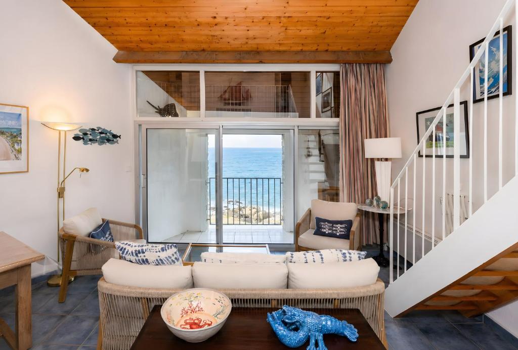 a living room with a view of the ocean at La Proue , duplex face mer in Arzon