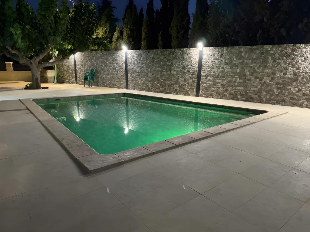 a swimming pool at night with a stone wall at Casa Bartolo in Vélez-Rubio