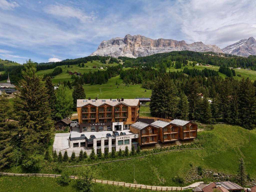 an aerial view of a large house in the mountains at Hotel La Müda in Badia