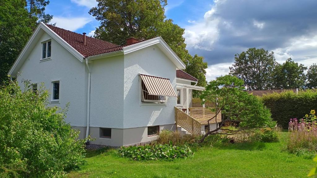 a white house with a balcony and a yard at Villa Emma in Alsterbro