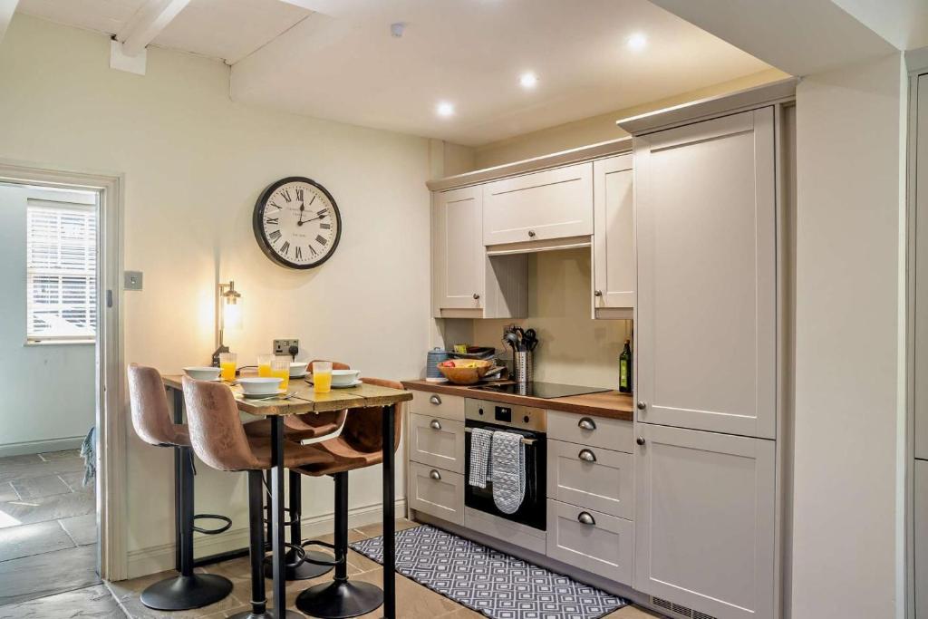 a kitchen with a table and a clock on the wall at 2 Bed in Cherry Burton oc-c37535 in Cherry Burton