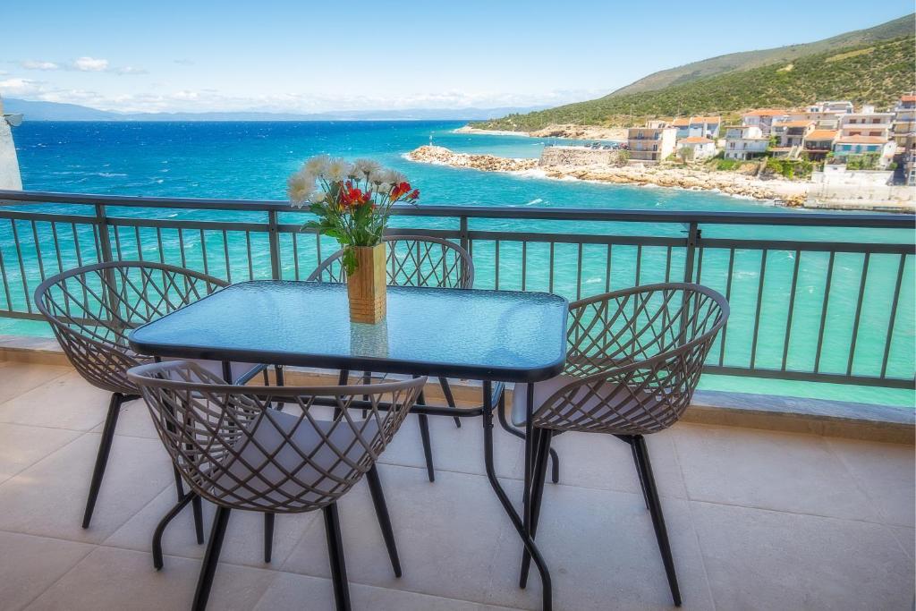 a table with chairs and a vase of flowers on a balcony at Sea U in Kalívia