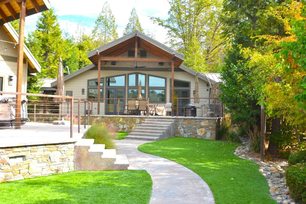 a house with a stone pathway leading to a house with a porch at Deer Lodge #2- Lake Front in Bass Lake