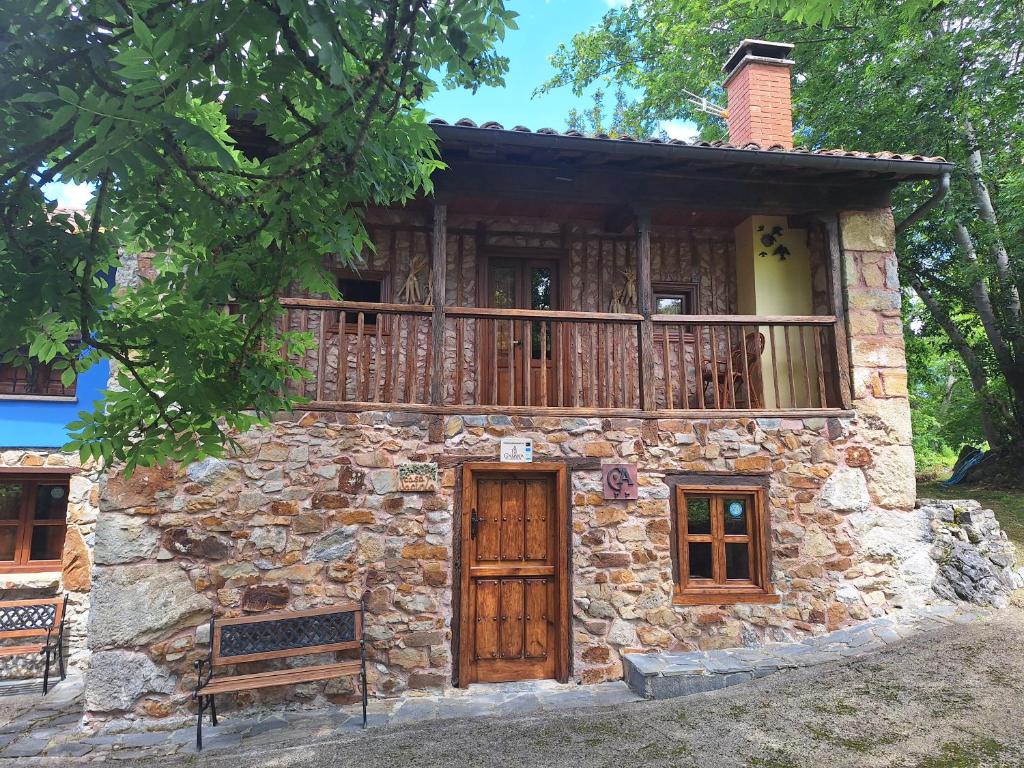 a stone house with a balcony on top of it at Casa Jacinta in Bimenes