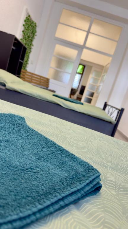 a bed with a blue blanket on top of it at Central Apartments Hof in Hof
