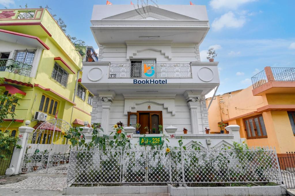 a white building with a fence in front of it at Hotel Elguse in kolkata