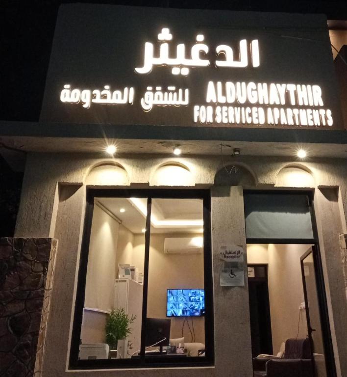 a sign on the front of a building with a television at الدغيثر للشقق المخدومه in Ash Shafa