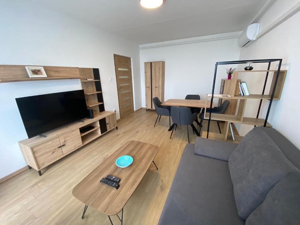 a living room with a couch and a table at Nagyerdő Naplemente Apartman Debrecen in Debrecen