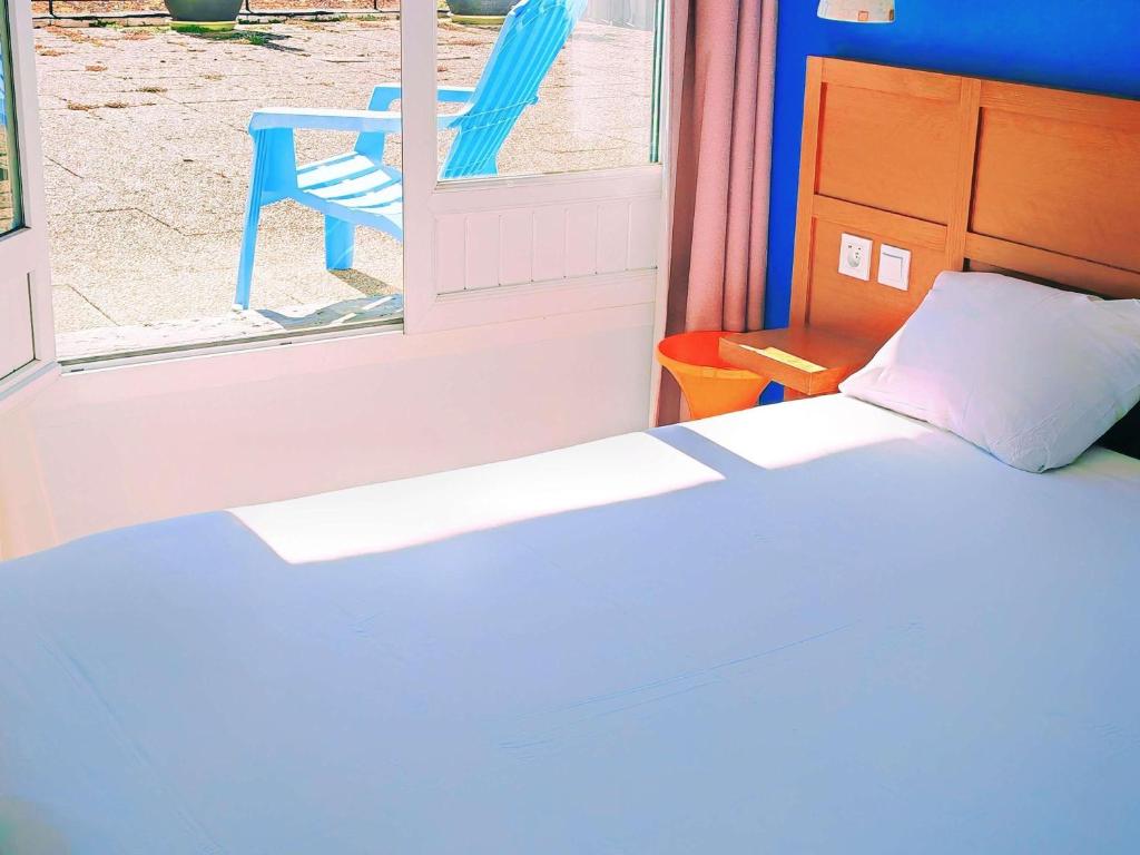 a bedroom with a bed and a window with a chair at ibis Styles Le Havre Centre in Le Havre