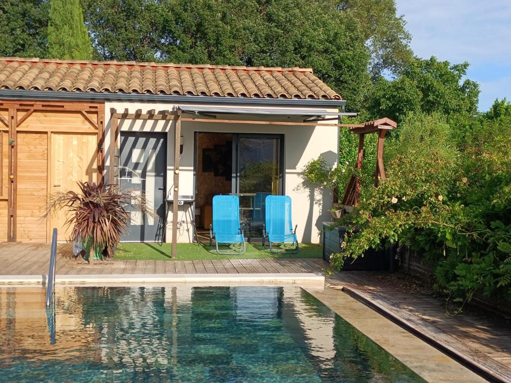 a house with a swimming pool in front of it at La cabane des jours heureux in Saint-Laurent-de-Carnols