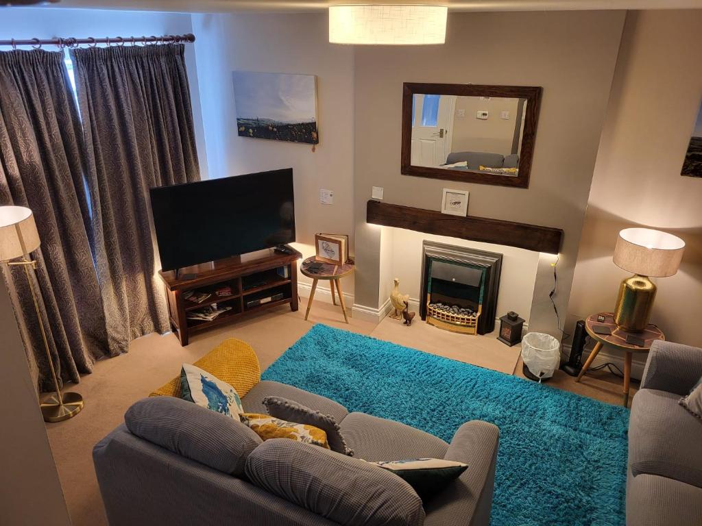 a living room with a couch and a television at Coddiwomple in Leyburn