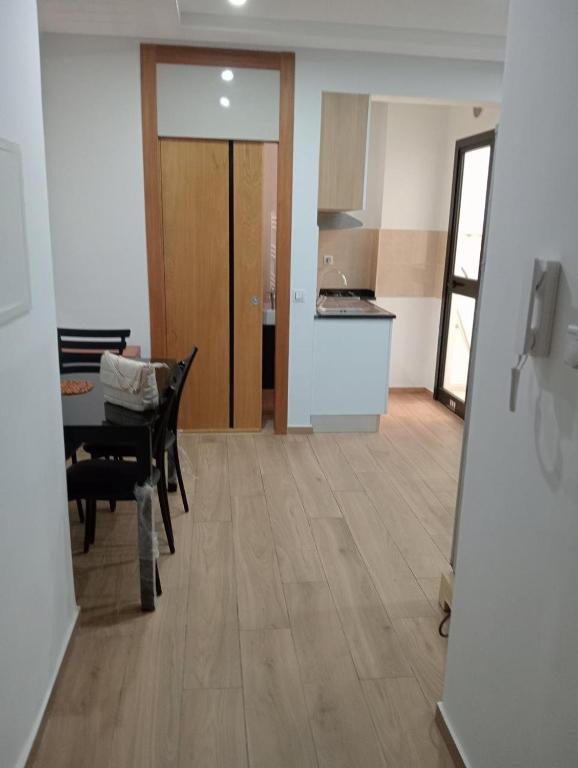 a living room with a table and a kitchen at Un Studio haut standing à Monastir in Monastir