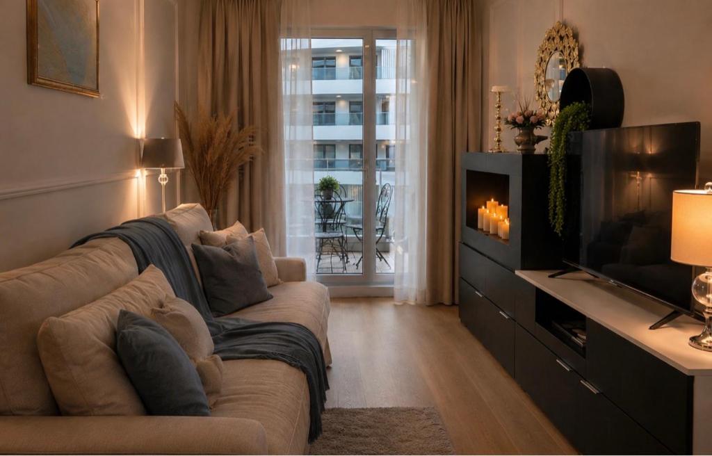a living room with a couch and a television at PEARL COAST Luxury Rogowo Pool Beach in Rogowo