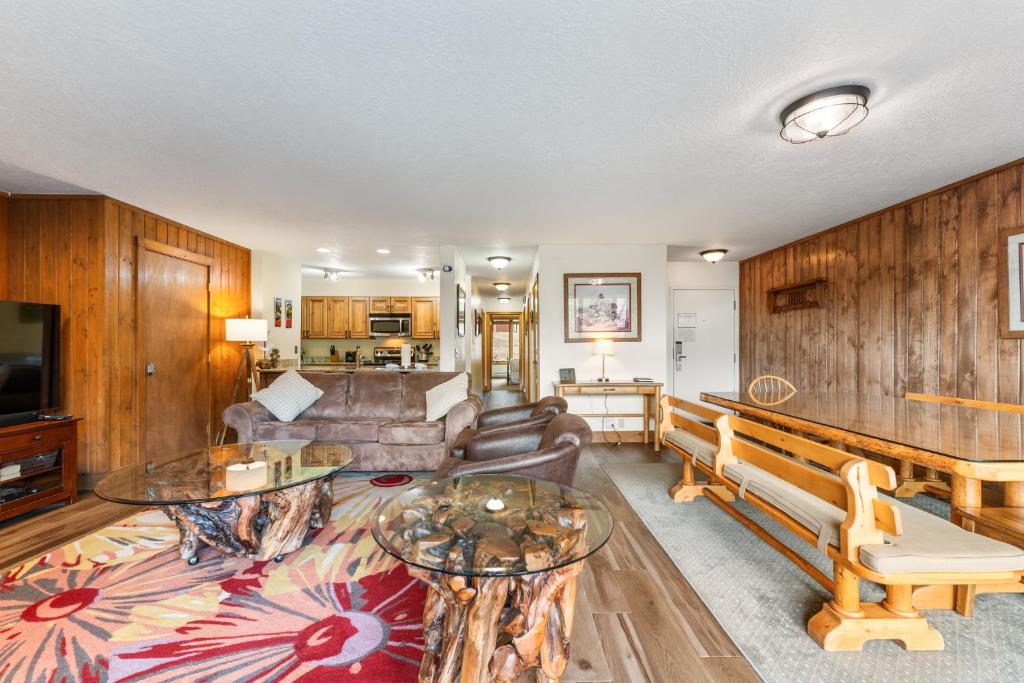 a living room with wooden walls and a couch and tables at Pines #2071 : 2 in Keystone