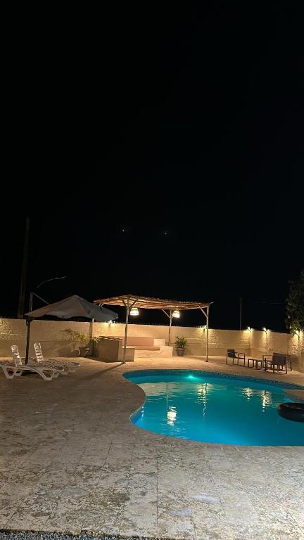 a swimming pool at night with chairs and umbrellas at Casa Kaibana - 6 Pax, con piscina, cerca del mar in Las Galeras