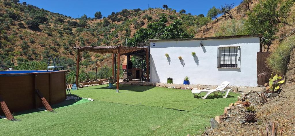 a building with a yard with a pool at La casa del rio cauche in Almogía