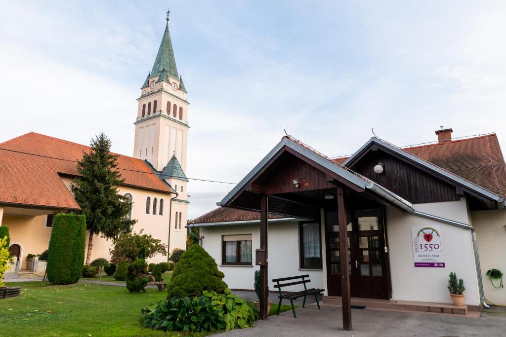 a church with a clock tower in the background at Hostel 1550 in Moravske-Toplice