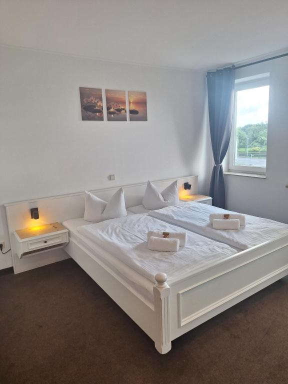 a large white bed in a room with a window at Hotel am Zellwald in Großschirma